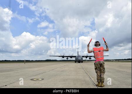 Il personale Sgt. Benjamin Stover, 821st risposta di emergenza squadrone di supporto capo equipaggio, esegue il marshalling di un C-130H Hercules aeromobili, durante l'esercizio sciopero del Nord a temoli Army Airfield, Mich il Agosto 9. Sciopero del Nord è una solida preparazione militare esercizio coordinato dall'esercito del Michigan Guardia Nazionale quali funzioni congiunte e multi-nazionale le forze armate di lavorare insieme per la forza totale integrazione. Foto Stock