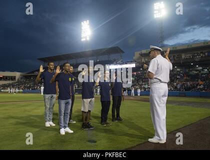 NORFOLK (Agosto 11, 2018), ammiraglio della roccia di chip, Commander, Navy Regione Mid-Atlantic, amministra il giuramento di arruolamento a Navy reclute nel ritardo dell' iscrizione programma durante il 2018 Navy Notte a Harbor Park Stadium. Il Norfolk maree Marina host notte annualmente per onorare gli uomini e le donne della marina degli Stati Uniti. Foto Stock