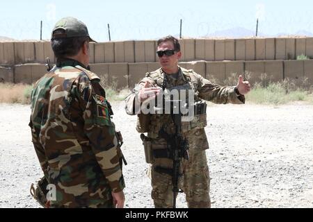 MAIDAN SHAHR, Afghanistan (6 agosto 2018) - USA Il personale dell'esercito Sgt. Christopher Humphreys, 1a forza di sicurezza brigata di assistenza (SFAB), si impegna con l'Esercito nazionale afgano Lt. Col. Mala Kuddin, ingegnere per il 4° Kandak, quarta brigata dell'203rd Corps. Foto Stock