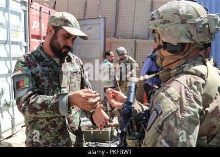 PUL-E 'ALAM, Afghanistan (7 agosto 2018) - USA Il personale dell'esercito Sgt. Michael Brant, 1a forza di sicurezza brigata di assistenza (SFAB), consiglia un esercito nazionale afghano soldato sul mantenimento delle armi nella provincia di Logar. Foto Stock