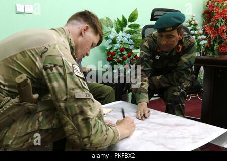 PUL-E 'ALAM, Afghanistan (7 agosto 2018) - USA Esercito Capt. David Zak, 1a forza di sicurezza brigata di assistenza (SFAB), consiglia l esercito nazionale afgano Il Mag. Abdul Zahir circa la sicurezza nella provincia di Logar. Foto Stock