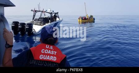 Una stazione della Guardia Costiera Marathon boatcrew gli stati si avvicina a un recipiente rustico con sovraccarico 17 cubani emigrati nei pressi di Maratona, Florida, il 10 agosto 2018. La guardia costiera e delle dogane e della protezione delle frontiere ha lavorato insieme ad interdire 17 cubani illegali e il loro rimpatrio torna a Bahia de Cabañas, Cuba. (Coast Guard foto) Foto Stock