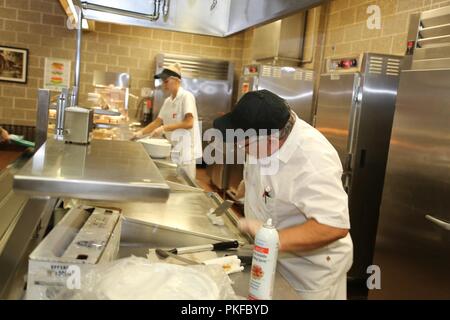 I dipendenti con l'appaltatore DCT Inc. opera nella struttura da pranzo nell'Edificio 50 su 3 Agosto 2018, a Fort McCoy, Wis. ogni volta un grande esercizio come una lotta contro la formazione per il supporto di esercizio avviene a Fort McCoy, migliaia di truppe hanno bisogno di essere alimentate. L'installazione del cibo-service team assicura che il bisogno è sempre soddisfatte. Il team che include il cibo Program Management Office e la sussistenza di alimentazione Ufficio di gestione con il Fort McCoy disponibilità logistica centro; il cibo full-service DCT contraente Inc.; e i fornitori di prodotti alimentari quali alimenti Sysco di Baraboo, Wis. Foto Stock