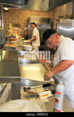 I dipendenti con l'appaltatore DCT Inc. opera nella struttura da pranzo nell'Edificio 50 su 3 Agosto 2018, a Fort McCoy, Wis. ogni volta un grande esercizio come una lotta contro la formazione per il supporto di esercizio avviene a Fort McCoy, migliaia di truppe hanno bisogno di essere alimentate. L'installazione del cibo-service team assicura che il bisogno è sempre soddisfatte. Il team che include il cibo Program Management Office e la sussistenza di alimentazione Ufficio di gestione con il Fort McCoy disponibilità logistica centro; il cibo full-service DCT contraente Inc.; e i fornitori di prodotti alimentari quali alimenti Sysco di Baraboo, Wis. Foto Stock