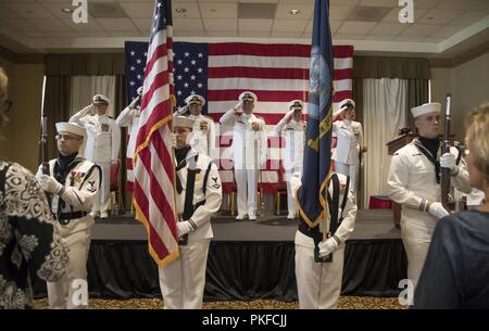 NORFOLK, Virginia (Agosto 10, 2018) La festa ufficiale saluta il national ensign durante la USS Gerald Ford (CVN 78) modifica del comando cerimonia al punto di vista a bordo della stazione navale di Norfolk. La modifica del comando cerimonia è un tempo onorata tradizione navale in cui il trasferimento di responsabilità, autorità e responsabilità avviene da un individuo ad un altro individuo. Foto Stock