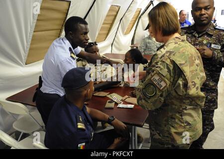 Lt. Yassive Mahamat Brahim, un elicottero tecnico in Ciad Air Force, condivide un pasto pronto a mangiare con U.S Air Force Master Sgt. Emily Vaughn, un personalista assegnato alla 818th Mobility Support squadrone di consulenza durante il partenariato africano Flightat Ramstein Air Base, Germania, e il Agosto 9, 2018. Il programma APF è Forze Aeree in Africa il premier di sicurezza del programma di cooperazione con i paesi dell'Africa nazioni partner per migliorare professional aviazione militare di conoscenze e competenze. Foto Stock