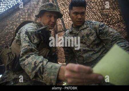 Marine Corps Mountain Warfare Training Center Bridgeport, CA - Cap. Lucas Helms, (sinistra) un funzionario dei servizi segreti e Lance Cpl. Robert Fagaragan, una macchina artigliere, entrambi con 3° Battaglione, quinto reggimento Marini, 1° Divisione Marine, parlare di movimenti di truppe e localizzazione durante la formazione di montagna Esercizio (MTX) 4-18 a bordo di Mountain Warfare Training Center Bridgeport, California, 30 luglio 2018. 3a Bn., 5 Marines hanno partecipato a MTX 4-18 per valutare la loro capacità di condurre la loro missione principale attività essenziali prima di attaccare al xi Marine Expeditionary Unit per la sua imminente distribuzione. Foto Stock