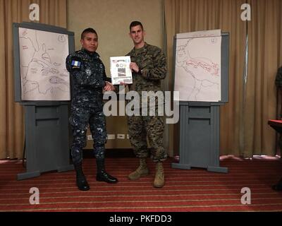 Stati Uniti Marine Capt Ryan Schab, con scopi speciali Air-Ground Marine Task Force - Comando Sud, riceve una certificazione di apprezzamento da parte di uno studente in Guatemala a conclusione di una due-settimana interagenzie Task Force programma di formazione con i funzionari e gli agenti del Guatemala nazionale della polizia civile nella Città di Guatemala, Guatemala, il 10 agosto 2018. Nel corso di due settimane, il SPMAGTF-SC istruttori insegnato in classi che coprisse ciascuna delle Marine Corps di pianificazione del processo di passi e la Marine Corps' di risposta rapido processo di pianificazione. A conclusione degli accademici parte del corso, il Foto Stock