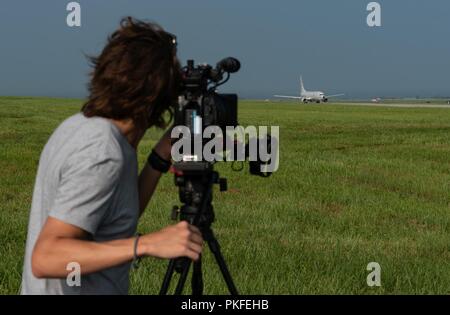 Il cameraman CNN Tom Booth documenti U.S. Navy P-8A Poseidon come si prepara a prendere il via il 10 agosto 2018, a Kadena Air Base, Giappone. Le agenzie di stampa sono stati invitati a volare su P-8A per conoscere la Poseidon la capacità e il ruolo che esso svolge nella regione del Pacifico. Foto Stock