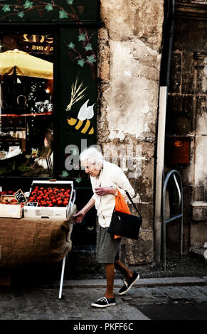 Una vecchia donna passeggiando per la città medioevale Semur-en-Auxois, nella Côte d'o reparto (Francia, 24/06/2010) Foto Stock