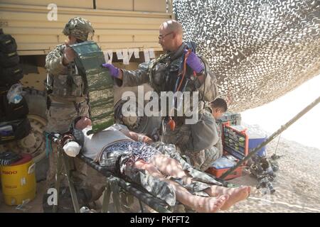 Stati Uniti I soldati dell esercito assegnati al 2° Battaglione, 112Reggimento di Fanteria, 56th Stryker Brigade Combat Team, ventottesima divisione di fanteria, Pennsylvania Esercito nazionale di protezione, fornire aiuto medico di un soldato ferito in un incidente il punto di raccolta durante un'azione decisiva la rotazione 18-09 presso il National Training Center, Fort Irwin, California, e il Agosto 5, 2018. Azione decisiva rotazioni di NTC garantire brigata dell'esercito contro squadre restino versatile, reattivo e costantemente disponibili per le attuali e future emergenze. Foto Stock