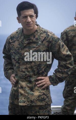 Oceano Pacifico - STATI UNITI Il personale marino Sgt. Raymundo Cardona, food service specialist con l'elemento di comando, xiii Marine Expeditionary Unit (MEU), guarda dopo la sua Marines durante una regolare distribuzione programmata dell'Essex anfibio gruppo pronto (ARG) e xiii MEU, 29 luglio 2018. L'Essex ARG/MEU team è un forte e flessibile, reattivo e forza coerente in grado di manovrare la guerra tra tutti i domini; esso è attrezzato e dotato di una soluzione scalabile in grado di rispondere a qualsiasi crisi di assistenza umanitaria e di soccorso in caso di catastrofe per le operazioni di emergenza. (Brevetto statunitense n. S. Marine Corps Foto Stock