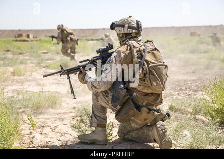 Una nuova Zelanda Defence Force Stati, con il gruppo di attività Taji rapido della forza di reazione, fornisce la sicurezza per i compagni di squadra di delimitazione durante un forze combinate live esercitazione antincendio presso il Camp Taji, Iraq, Agosto, 10, 2018. Una coalizione creato a partire da una vasta comunità internazionale continuerà a fornire il suo sostegno al popolo dell'Iraq al fine di potenziare le capacità della nazione per garantire la sicurezza e la stabilità. Foto Stock