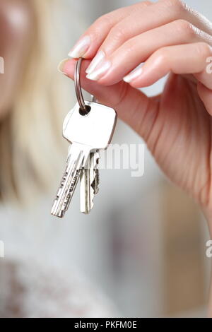 Un portachiavi con varie chiavi in mano da donna Foto Stock