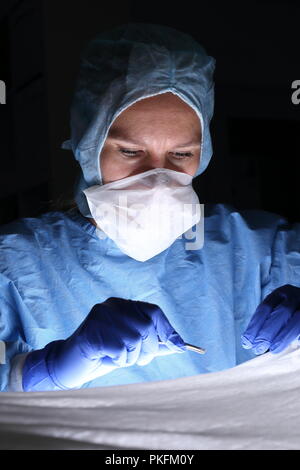 Una femmina di ambulatorio medico concentrato in una operazione Foto Stock