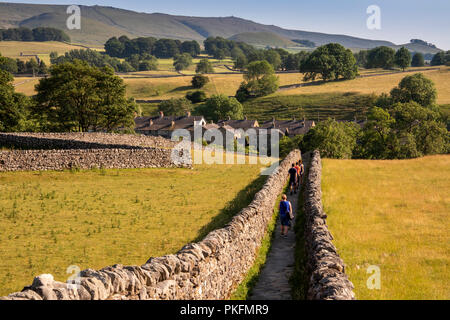 Regno Unito, Yorkshire, Wharfedale, Grassington, Sedber Lane, persone che camminano giù vicolo che conduce a Linton cade in estate Foto Stock