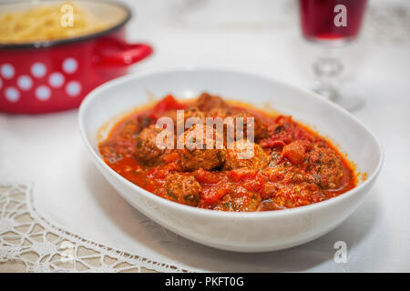 Deliziose polpette di carne di manzo macinato in una piccante salsa di pomodoro servita su una piastra bianca Foto Stock
