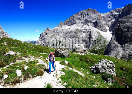 Escursionista femmina nella parte anteriore del Zsigmondy o rifugio Comici, Dolomiti di Sesto - Alta Pusteria - Alto Adige, Italia Foto Stock