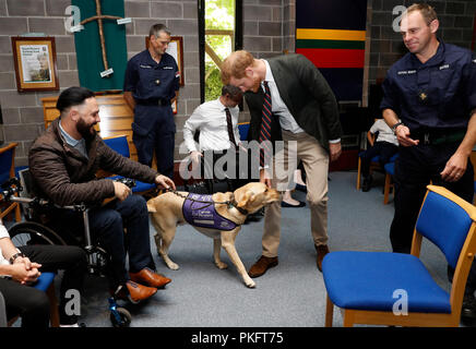 Il Duca di Sussex parla con Royal Marine Phil Eaglesham e il suo cane Cooper, durante una visita al Royal Marines Commando Training Center in Lympstone, Devon. Foto Stock