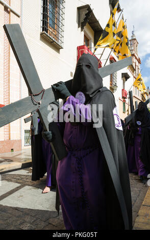 Penitente con la croce e il rosario presso la Semana Santa, la Settimana Santa, Siviglia, Andalusa, Spagna Foto Stock