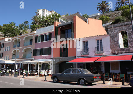 Spagna. Isole Baleari. Minorca. Mahón. Harbourside edifici con ristoranti e caffetterie con parcheggiato classico auto Mercedes. Foto Stock