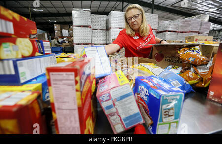 Davenport, Iowa, USA. Xiii Sep, 2018. Cathy montanti di un volontario da Wells Fargo ordina e passaggi donato spuntini dal locale dei negozi di generi alimentari presso il fiume piega Foodbank a Davenport Giovedì 13 Settembre, 2018. Credito: Kevin E. Schmidt/Quad-City volte/Quad-City volte/ZUMA filo/Alamy Live News Foto Stock