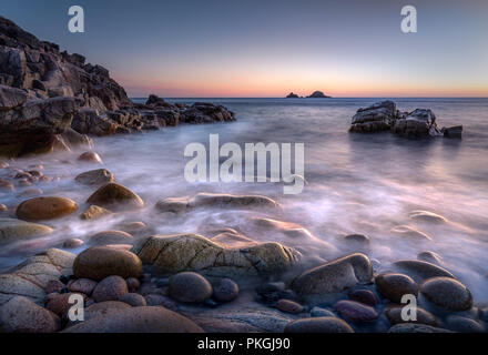 Crepuscolo, Porth Nanven, con bella luce sulle rocce e ciottoli sulla spiaggia, Cornwall Foto Stock