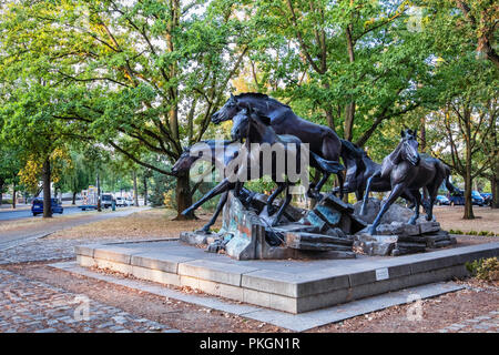 Berlino,Dahlem. La scultura in bronzo di cinque cavalli selvaggi saltando resti del muro di Berlino. Regalo da STATI UNITI D'AMERICA PER FDR commemora il giorno in cui il muro è caduto Foto Stock