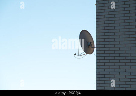 Antenna satellitare sul muro di mattoni Foto Stock