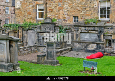 Edimburgo in Scozia il cimitero o KIRKYARD DI Greyfriars Kirk di rosso e un sacco a pelo con la persona all'interno di Foto Stock