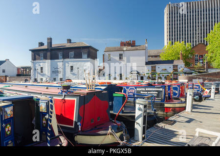 Strette colorate barche ormeggiate in Regency Wharf in Gas Street Basin, Birmingham in bright sole autunnale Foto Stock