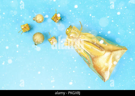 Sacchetto oro con doni su un tavolo blu. Nuovo anno 2019, Buon Natale. Appartamento laico, vista dall'alto, spazio di copia Foto Stock