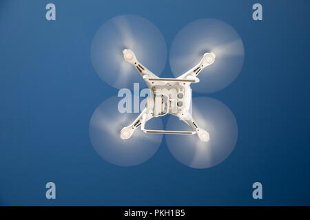 Drone Quadcopter dal basso contro un cielo blu. Foto Stock