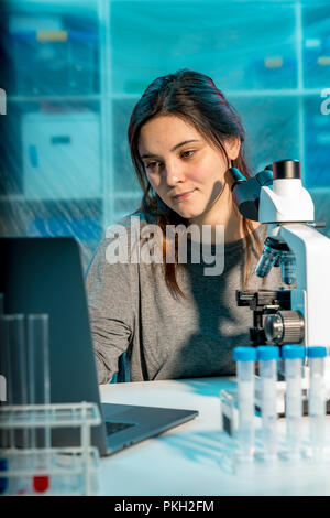 Donna scienziato ricercatore di condurre un esperimento in un laboratorio Foto Stock