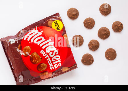 Pacchetto di Maltesers pulsanti aprono con contenuto versato set versato su sfondo bianco - poco cioccolato al latte Tondi riempiti con pezzi di malto Foto Stock