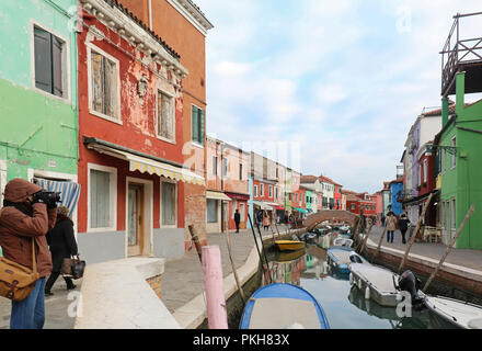 I turisti e i locali a piedi attorno a isola di Burano strade prendendo fotografie e godendo di architettura circostante Foto Stock