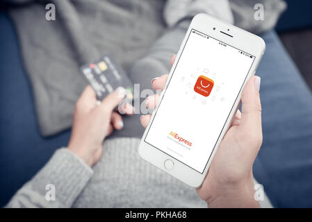 Kiev, Ucraina - 24 Gennaio 2018: Donna azienda Apple Iphone 8 plus con carico Aliexpress mobile app a casa closeup. Foto Stock