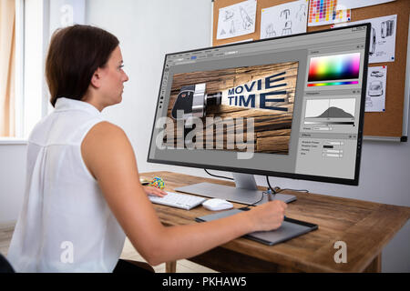 Designer femmina Modifica immagine in computer con tavoletta grafica Foto Stock