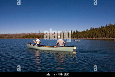 Un centro di età compresa tra i coniugi paddling una canoa su Waldo lago, una caldera vulcanica lago nel centro di Oregon Cascades vicino alla città di Oakridge. Foto Stock