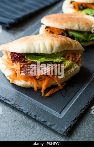 Taiwan ha Pane Pita Bun panino Gua Bao con pancetta affumicata, fette di carota e verde dall'Asia. / Pastrami sandwich pastirma Foto Stock