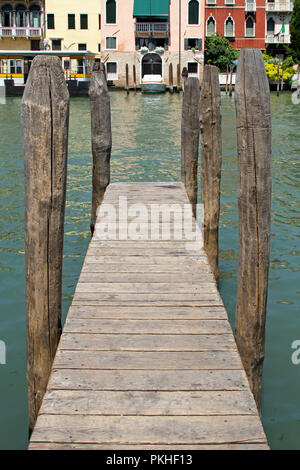 Il molo di legno con vecchie colonne a venezia canal Foto Stock