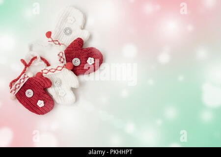 Due coppie di inverno di decorazione luminosa di colore rosso e bianco muffole, fiocchi di neve su sfondo colorato close-up Foto Stock