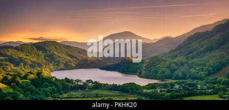 Il sole che splende attraverso un passo di montagna su Llyn Gwynant, Snowdonia (Eryri), il Galles (Cymru), Regno Unito Foto Stock