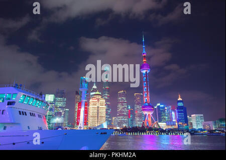 Nave da crociera nel porto di Shanghai downtown, grattacieli di architettura moderna e tv tower illuminata di notte, Cina Foto Stock