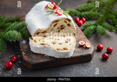 Natale Stollen. Tradizionale tedesco, festiva europea Dessert. Concetto di vacanza decorate con rami di abete e mirtilli rossi. Foto Stock