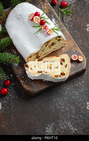 Natale Stollen. Tradizionale tedesco, festiva europea Dessert. Concetto di vacanza decorate con rami di abete e mirtilli rossi. Foto Stock