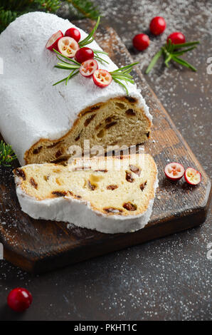 Natale Stollen. Tradizionale tedesco, festiva europea Dessert. Concetto di vacanza decorate con rami di abete e mirtilli rossi. Foto Stock