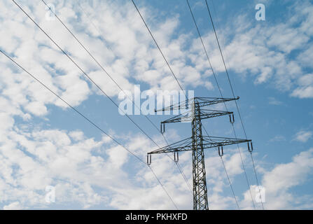 110 kV tensione alta torre su un cielo blu punteggiato di nuvole - due fili di massa Foto Stock