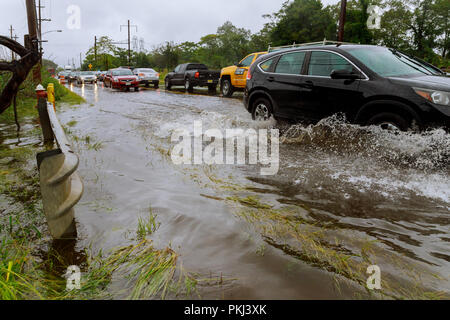 10 settembre 2018 NJ USA: una linea di corsa di automobili su una strada sotto l'acqua. Alluvione sulla strada splash da un auto Foto Stock