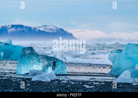 Ruggito mare e belle dei pezzi di ghiaccio sulla spiaggia Jökulsarlon in inverno Foto Stock